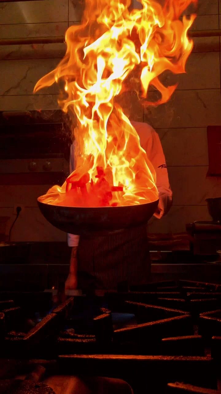 A pan erupting in flame over a gas range