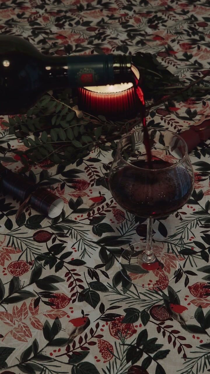 Red wine poured beside candlelight