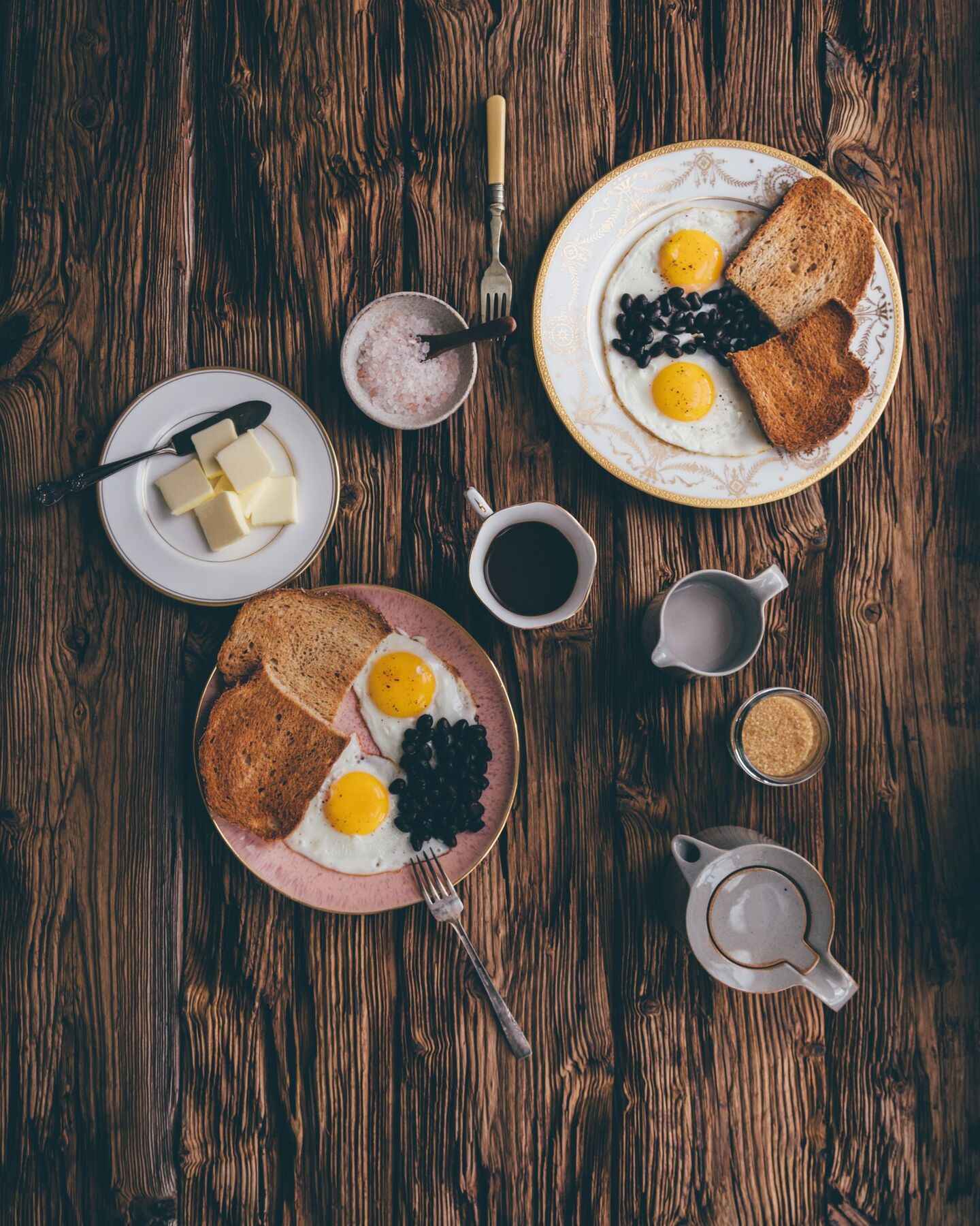 Eggs, toast and coffee laid out on a weathered wooden table